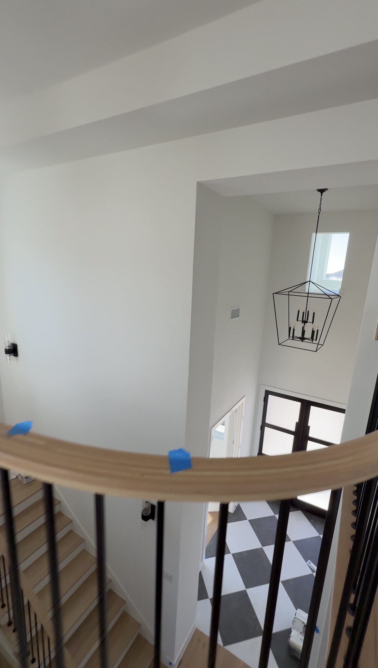 Luxury new construction entryway during final walkthrough with black and white tile and staircase detail