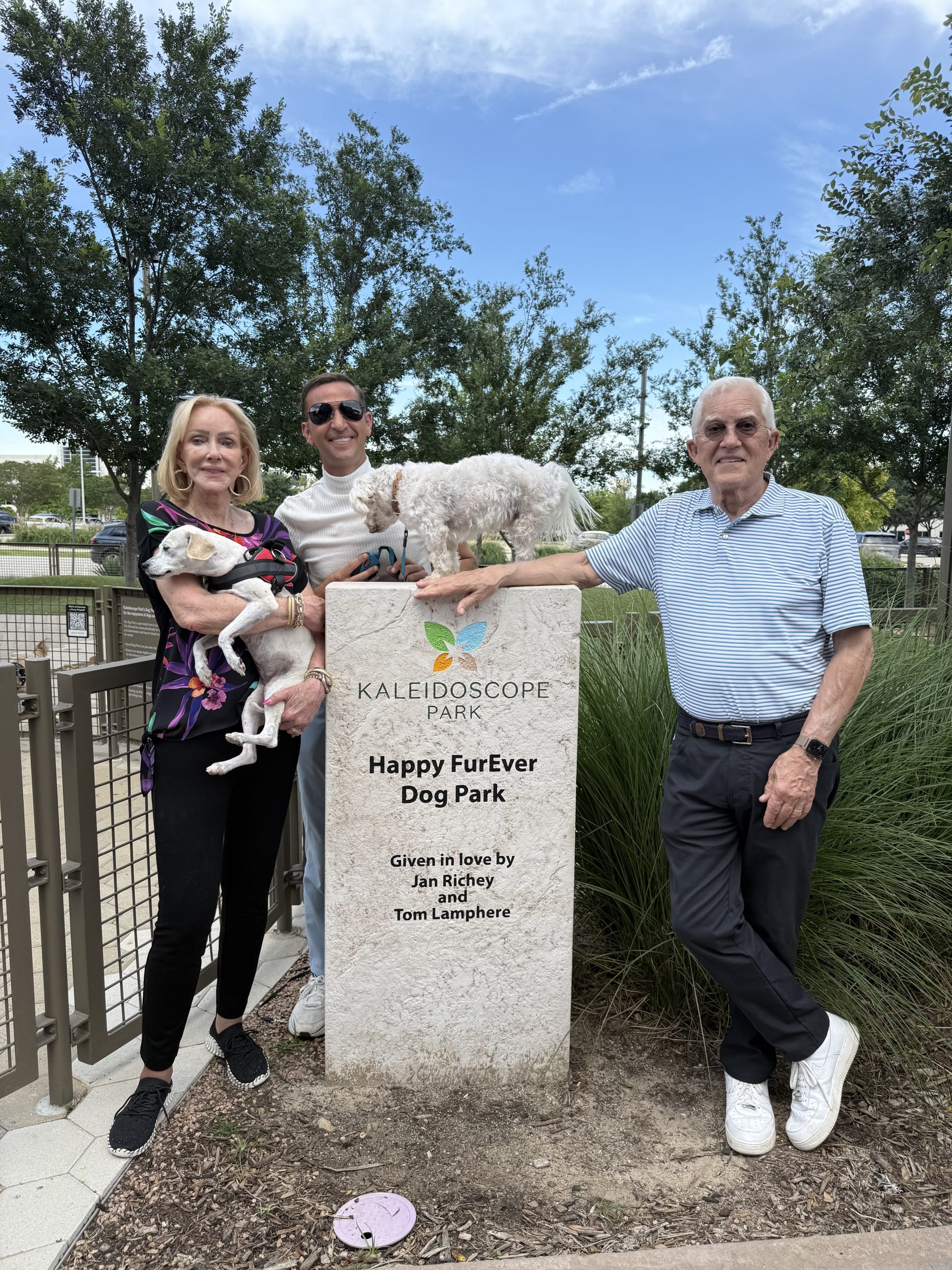 Jan Richey, Carl Hill, and Tom Lamphere at the Happy FurEver Dog Park sign in Frisco, Texas