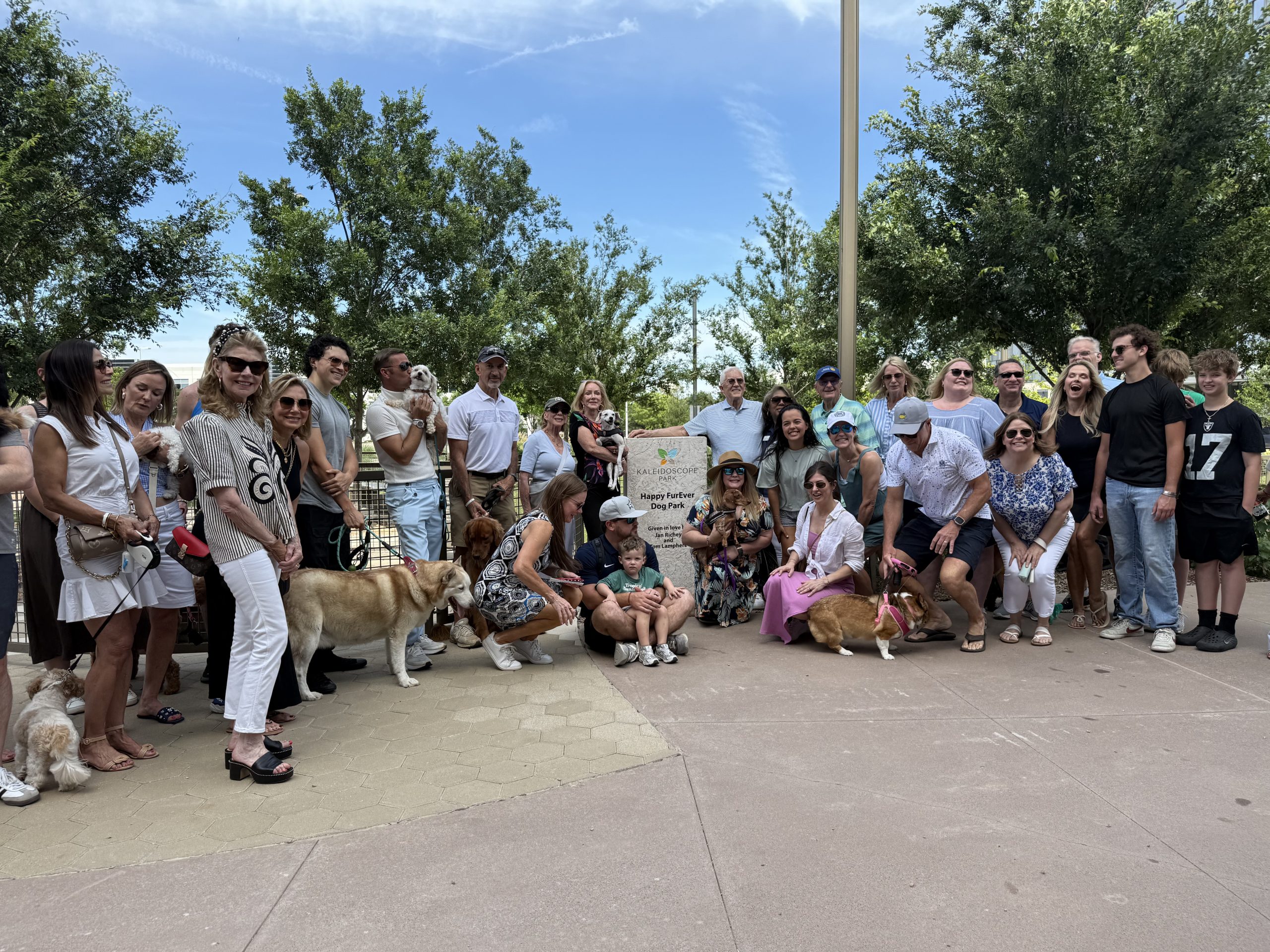 Happy FurEver Dog Park ribbon cutting attendees gather for a group photo at Kaleidoscope Park in Frisco, Texas