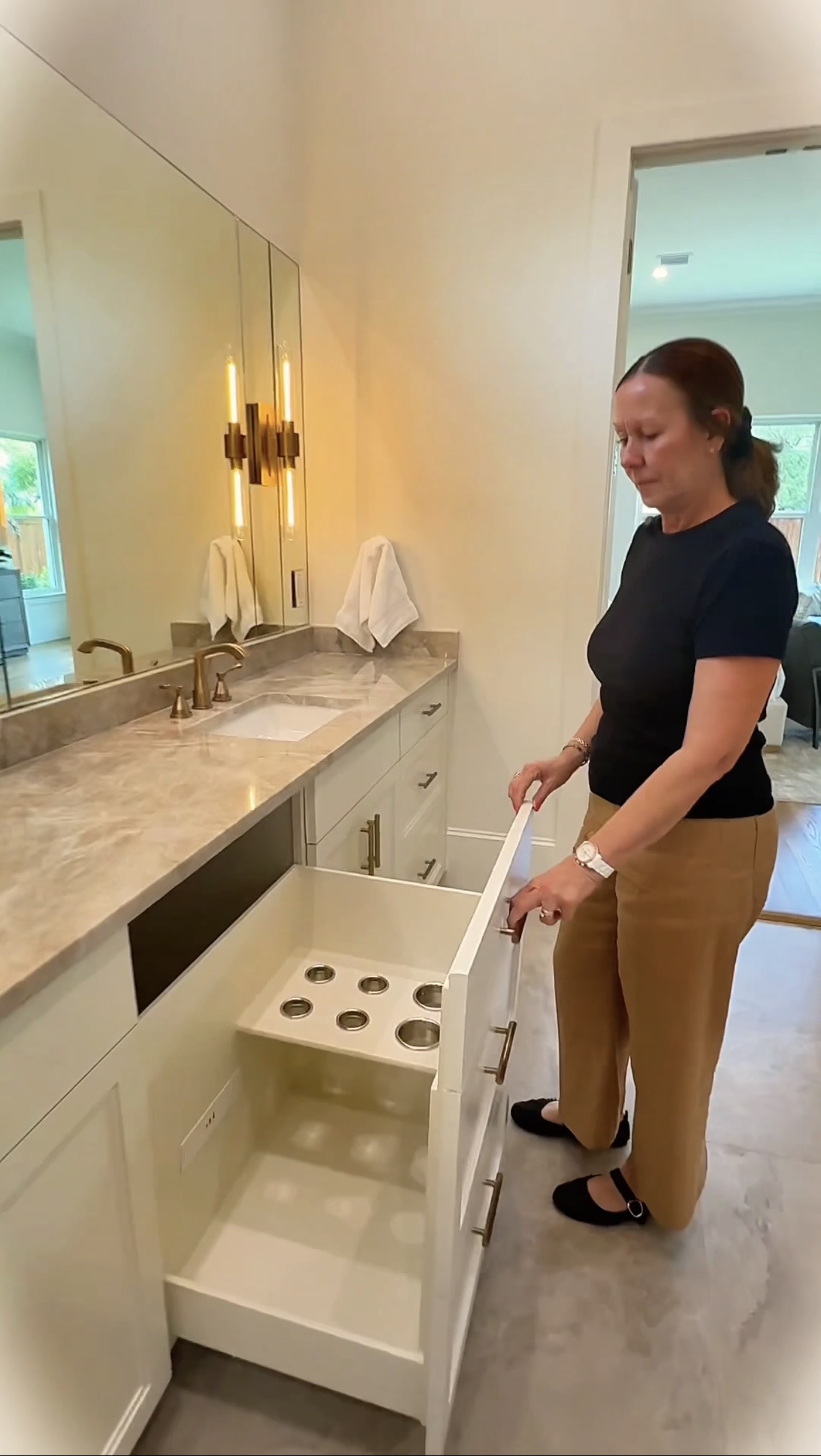 Lisa Broussard demonstrating hidden appliance drawer at 9939 Ontario Lane